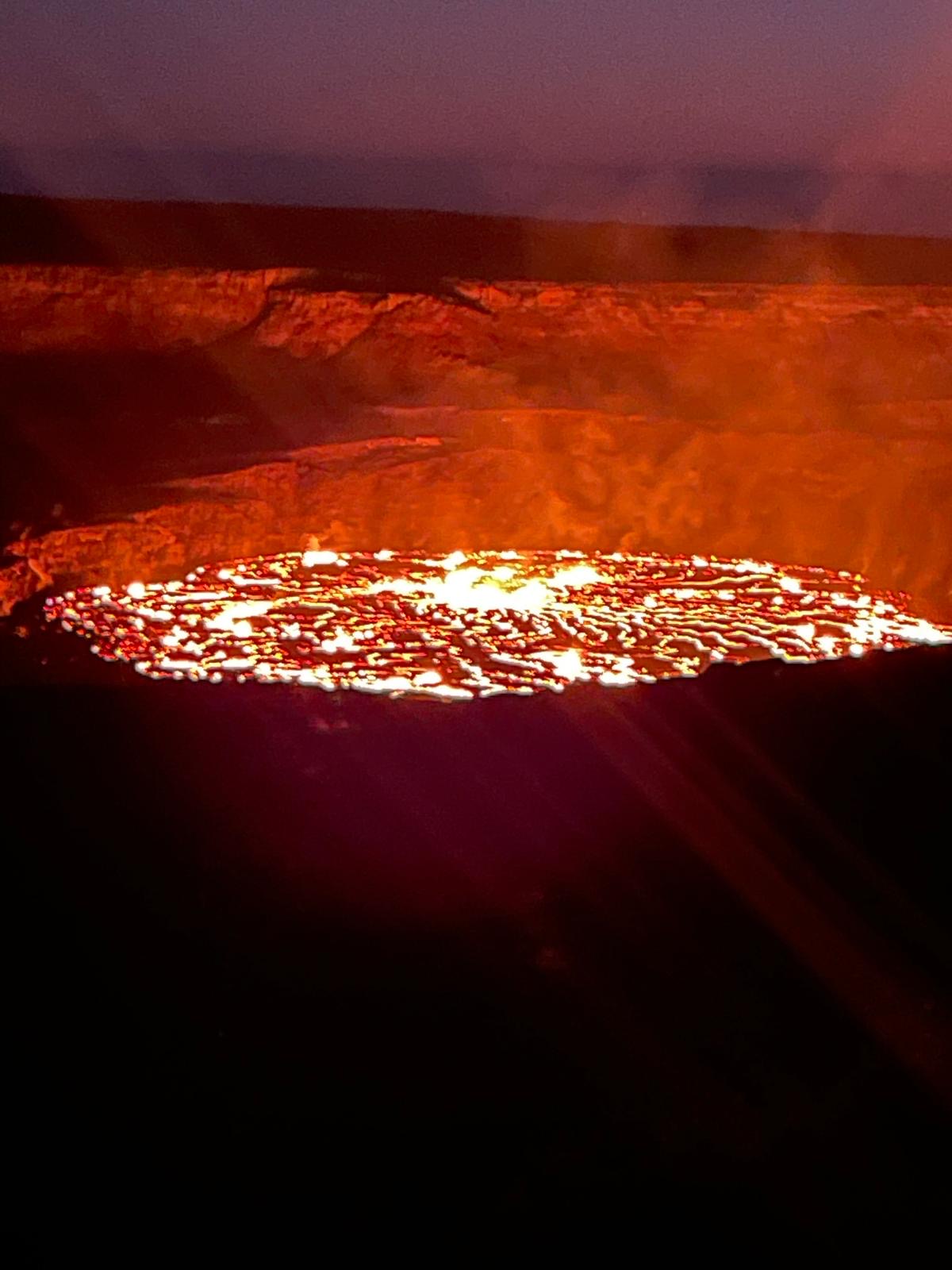 Incandescent lava lake surface glowing at night