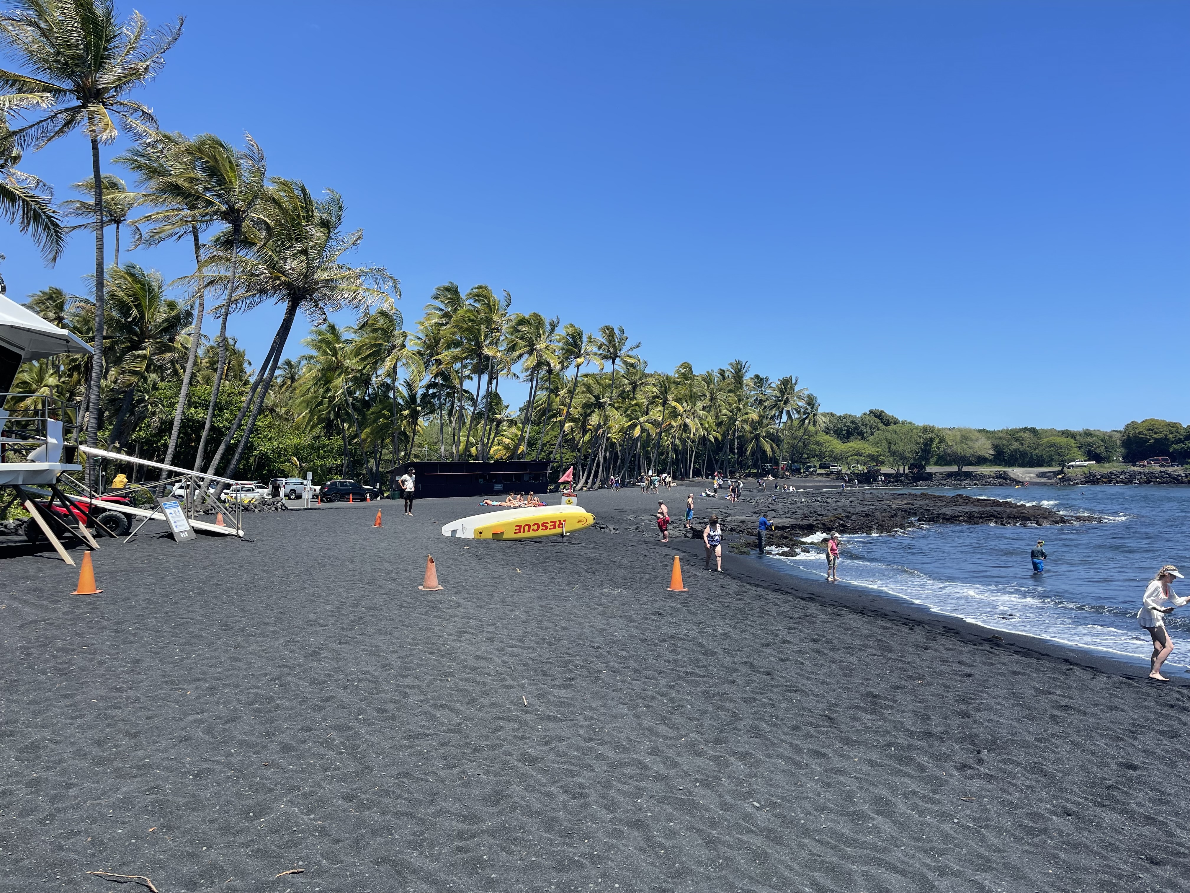 Visitors on a Big Island black-sand beach